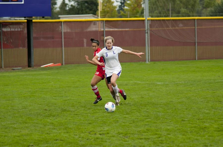 Freshman forward Zoe Langsdorf out runs Pacific University freshman defender Taylor Gillespie during the Wildcats’ Oct. 8 game at home. 	Joel Ray/Photo editor