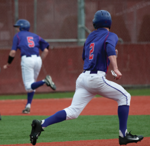 Senior All-American Tim Wilson races toward second base after hitting a line drive single up the middle, scoring senior Jordan Harlow. Wilson went four for five on the day with one triple and an RBI.  Tyson Takeuchi/Senior photographer