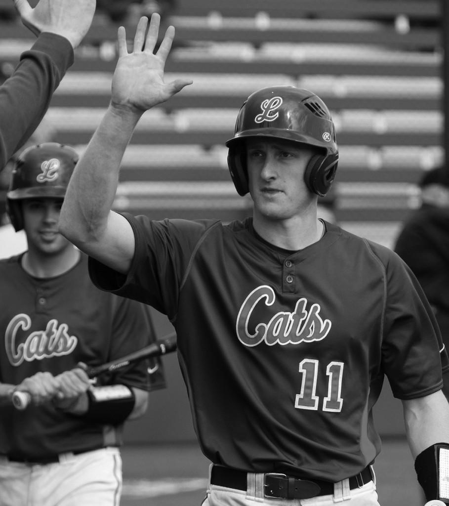 Junior Kramer Lindell gives a high five to the coach after hitting a two-run home run against Pomona-Pitzer College on April 11. Kramer hit two doubles and scored four runs for the Wildcats. Photo courtesy of Sports Information 