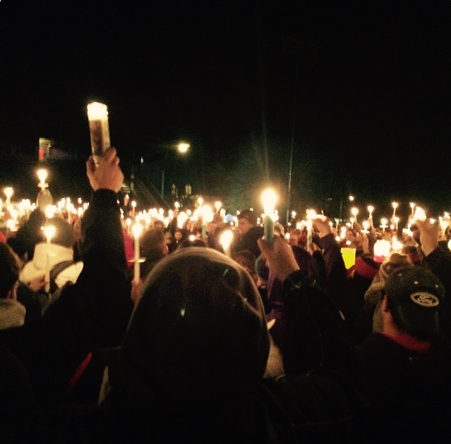 Students raise their candles up toward the night sky in loving memory of Parker Moore.