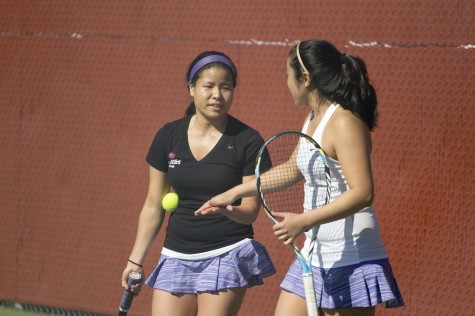 Doubles partners and seniors Kaila Nip and Kelly Watanabe high five after a triumph match against George Fox on March 7. 