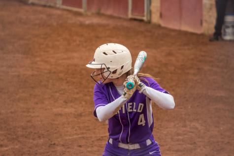 Jacinda Swiger (#4) getting setup and preparing to bat for Linfield.