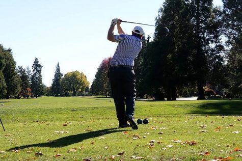 Freshman Raegan Barr lines up to chip onto the green of the third hole