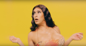 Bad Bunny dressed in drag with long brown hair in front of yellow background.