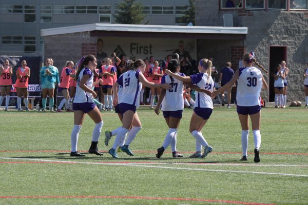 Women's soccer celebrates during a game.